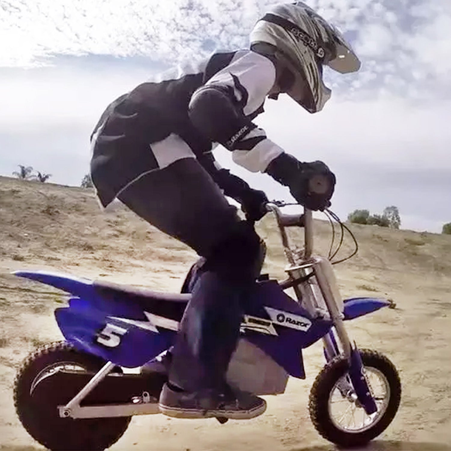 12-1/2x2.75 Dirt Bike Tire for Avigo Extreme Motorcross Bike, featuring a knobby tread pattern, designed for off-road use. A person is seen riding a motocross bike, providing context for the tire's application.