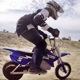 12-1/2x2.75 Dirt Bike Tire for Avigo Extreme Motorcross Bike, featuring a knobby tread pattern, designed for off-road use. A person is seen riding a motocross bike, providing context for the tire's application.