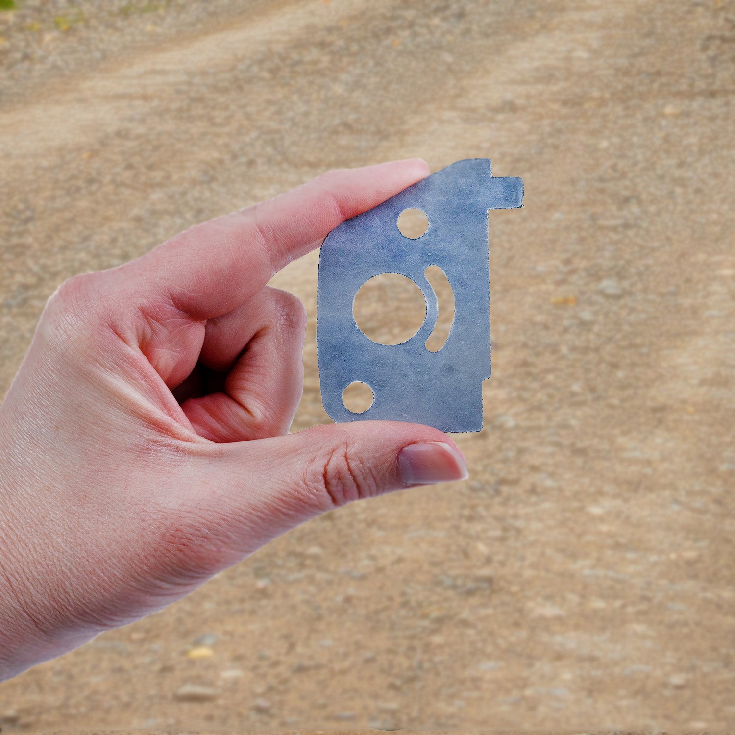 Hand holding the Carburetor, Air Cleaner, & Air Inlet Gasket for the Baja Doodle Bug (DB30), showcasing its precise design for replacing earlier DB30R-238 and DB30R-234 gaskets.