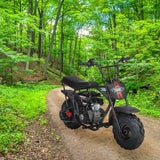 145/70-6 Tire for the Monster Moto / Mega Moto Classic 105cc & MM-B80 80cc Mini Bikes, featuring an aggressive V-tread pattern, mounted on a black motorcycle on a dirt road in the woods.