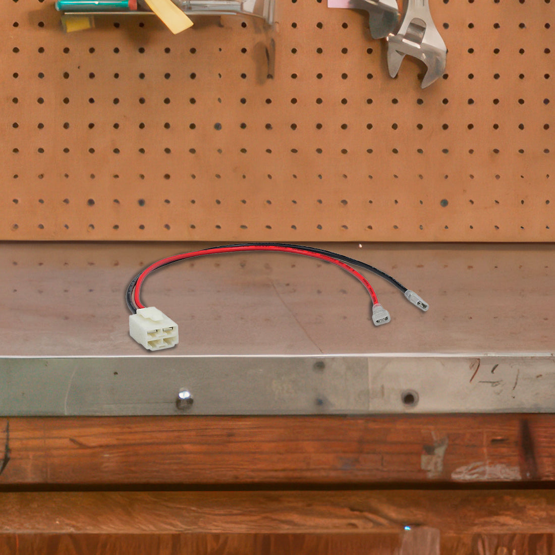 4-Pin, 2-Wire Battery Wiring Harness for Razor Scooters shown on a tool board with visible wires and wrenches, highlighting its connection capability for two 12-volt batteries in series.