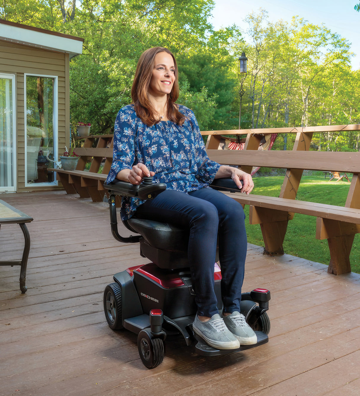 Black Vinyl Co-Molded Full Length Armrest Pad for Jazzy Power Chairs & Pride Mobility Scooters (Set of 2), shown installed on a mobility scooter with a woman sitting and smiling.