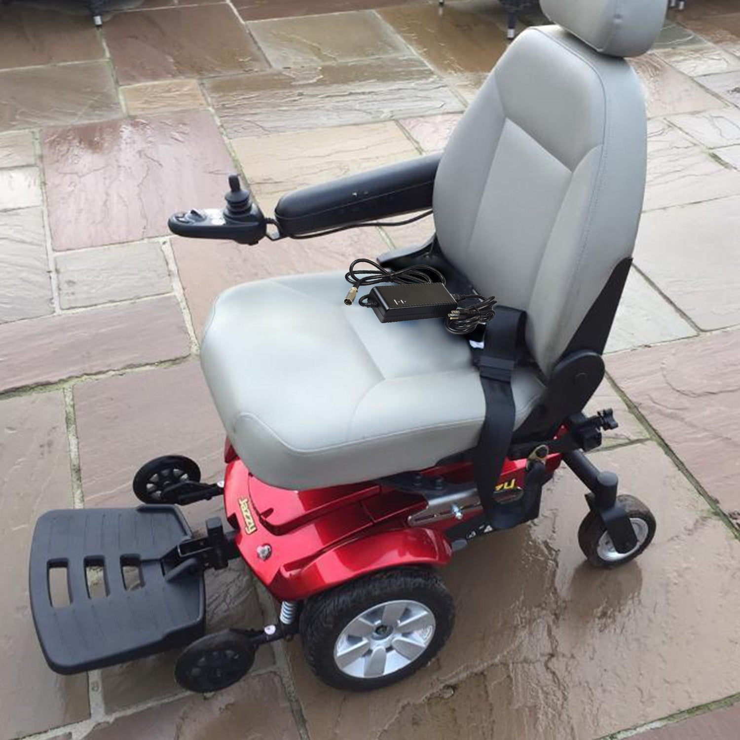 24 Volt 3.5 Amp Battery Charger for Pride Revo Scooter, featuring an XLR connector, power cord, and adapter, displayed on a patio with a wheelchair in the background.