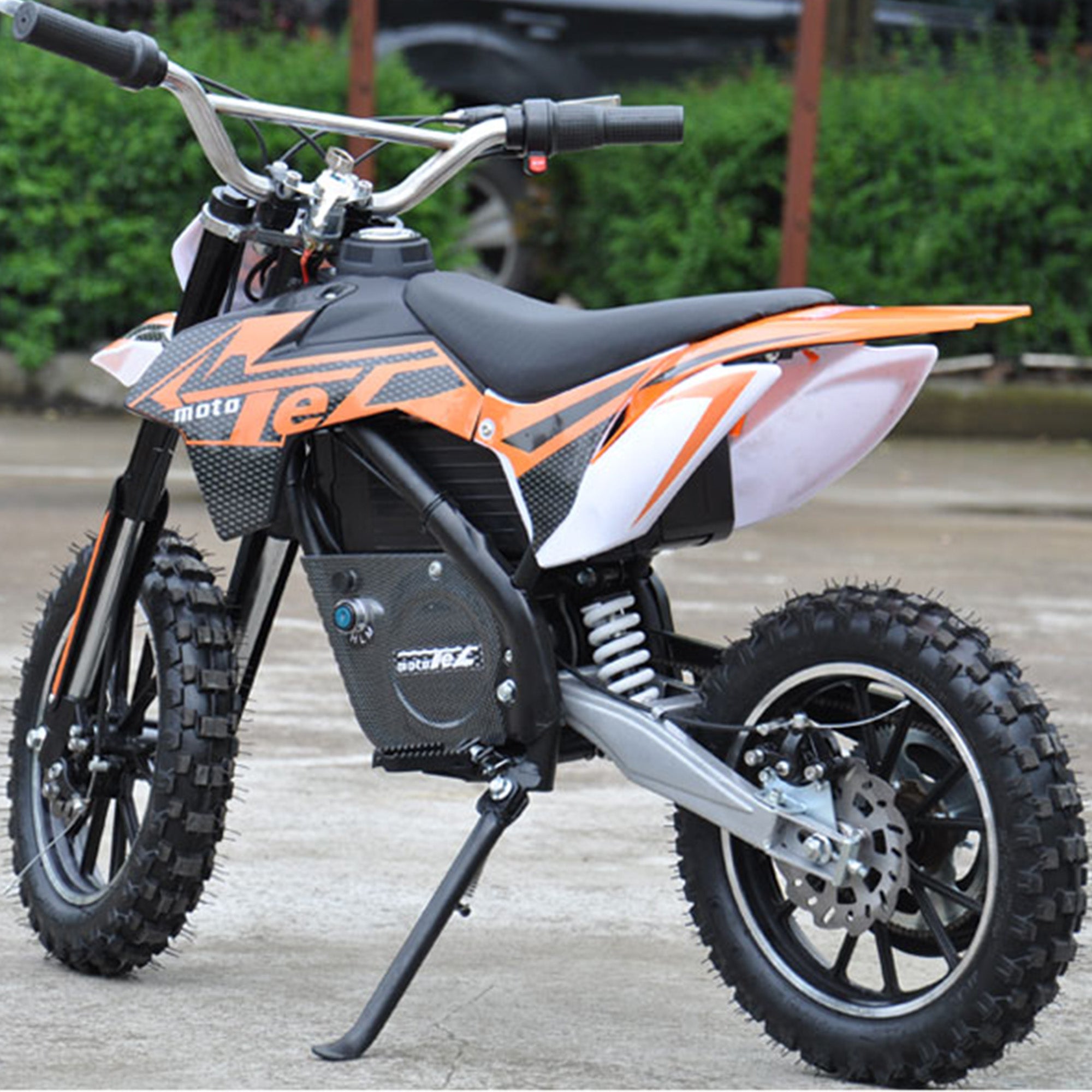 2.50-10 Dirt Bike Tire with Directional Knobby Tread mounted on a small motorcycle parked on concrete, highlighting the tire's intricate tread pattern and sturdy construction.