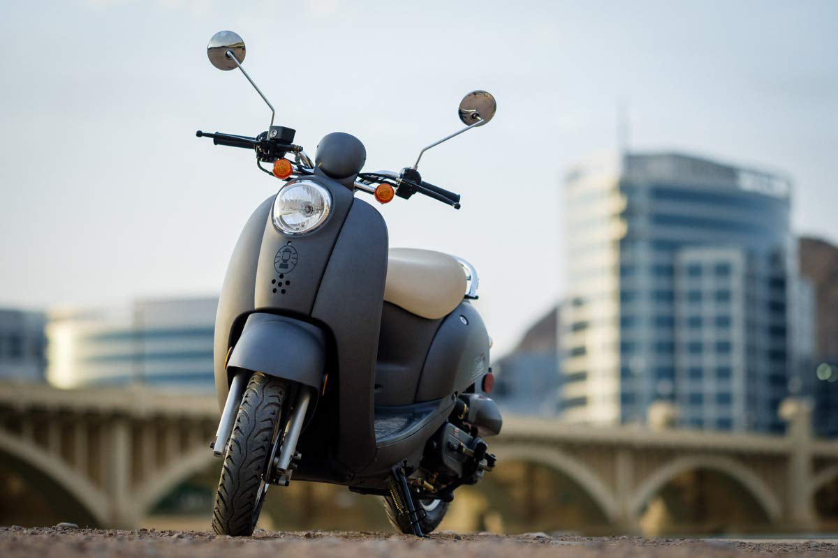 A7RTC Spark Plug displayed alongside a black scooter, highlighting its use in various scooter engines like Baja Sun City 50, Honda, KYMCO, and Baccio models.