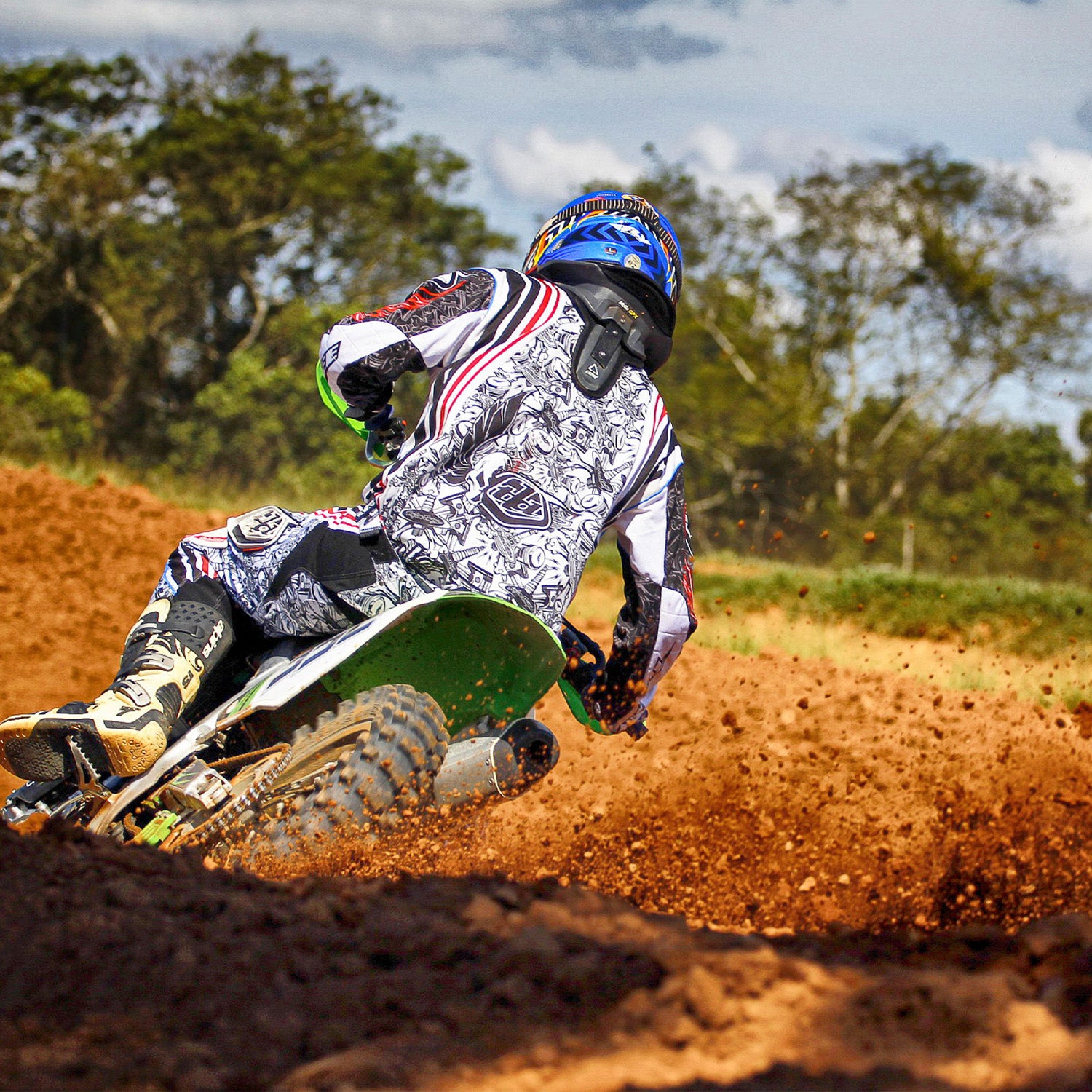 A person riding a dirt bike featuring a 3.00-12 (80/100-12) Tire with JK620 Knobby Tread for Baja, Coolster, & Honda Dirt Bikes, showcasing durable performance on rugged off-road terrain.