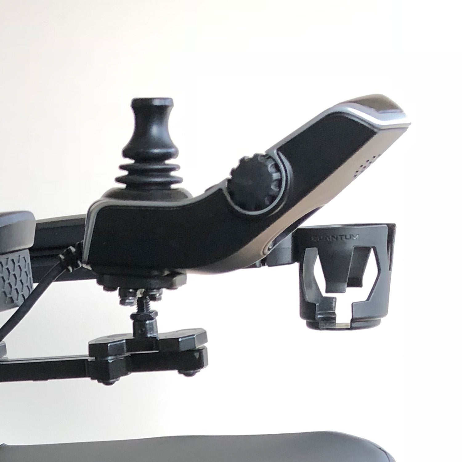 Close-up of a cup holder for Quantum power chairs with Tru-Balance seating, showcasing the secure mounting mechanism designed for T-slot channels on armrests, side rails, or accessory bars.