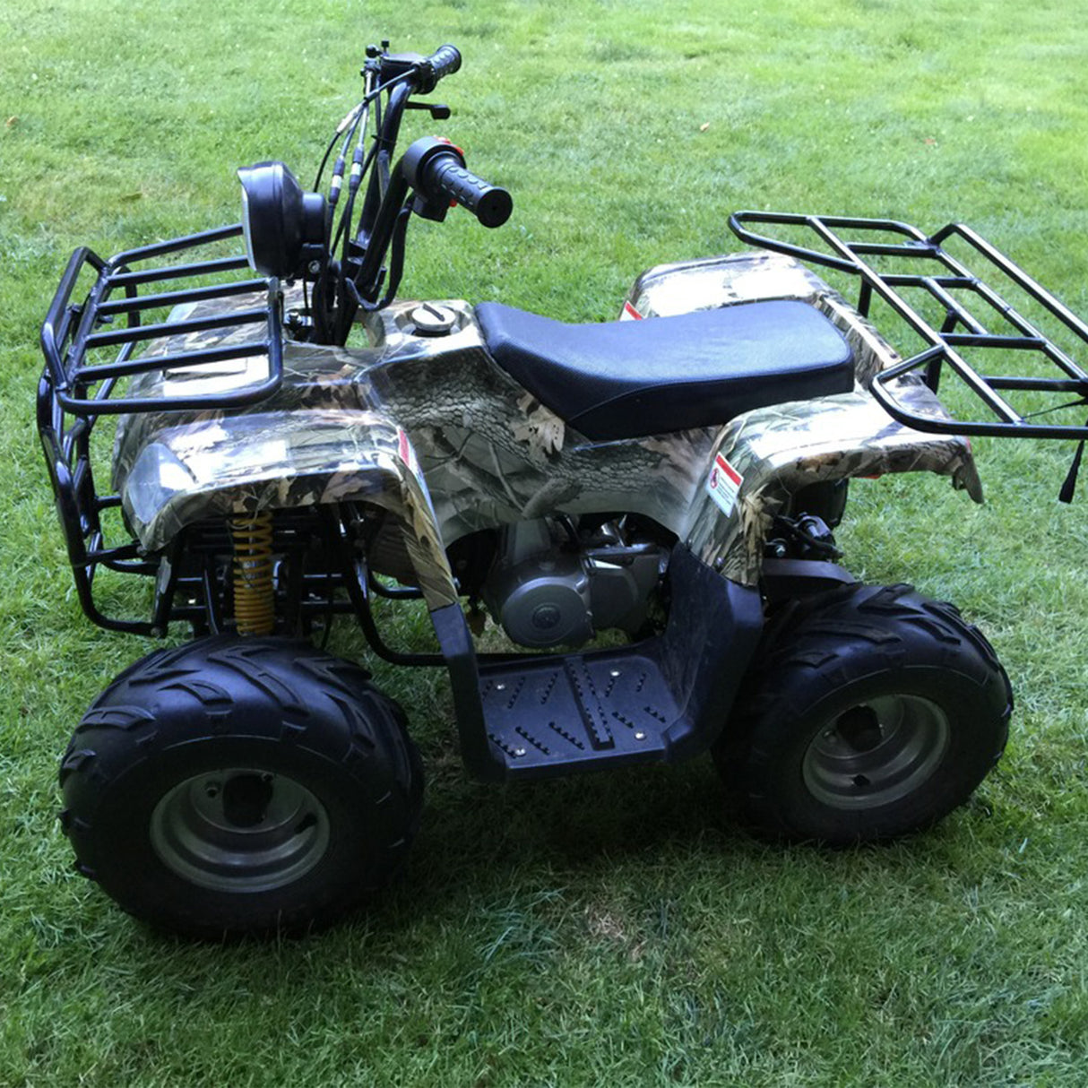 145/70-6 Tire with V-Tread for the Baja Blitz, Dirt Bug, Doodle Bug, & Racer Mini Bikes, shown on a small all-terrain vehicle parked on grass, highlighting its aggressive tread pattern.