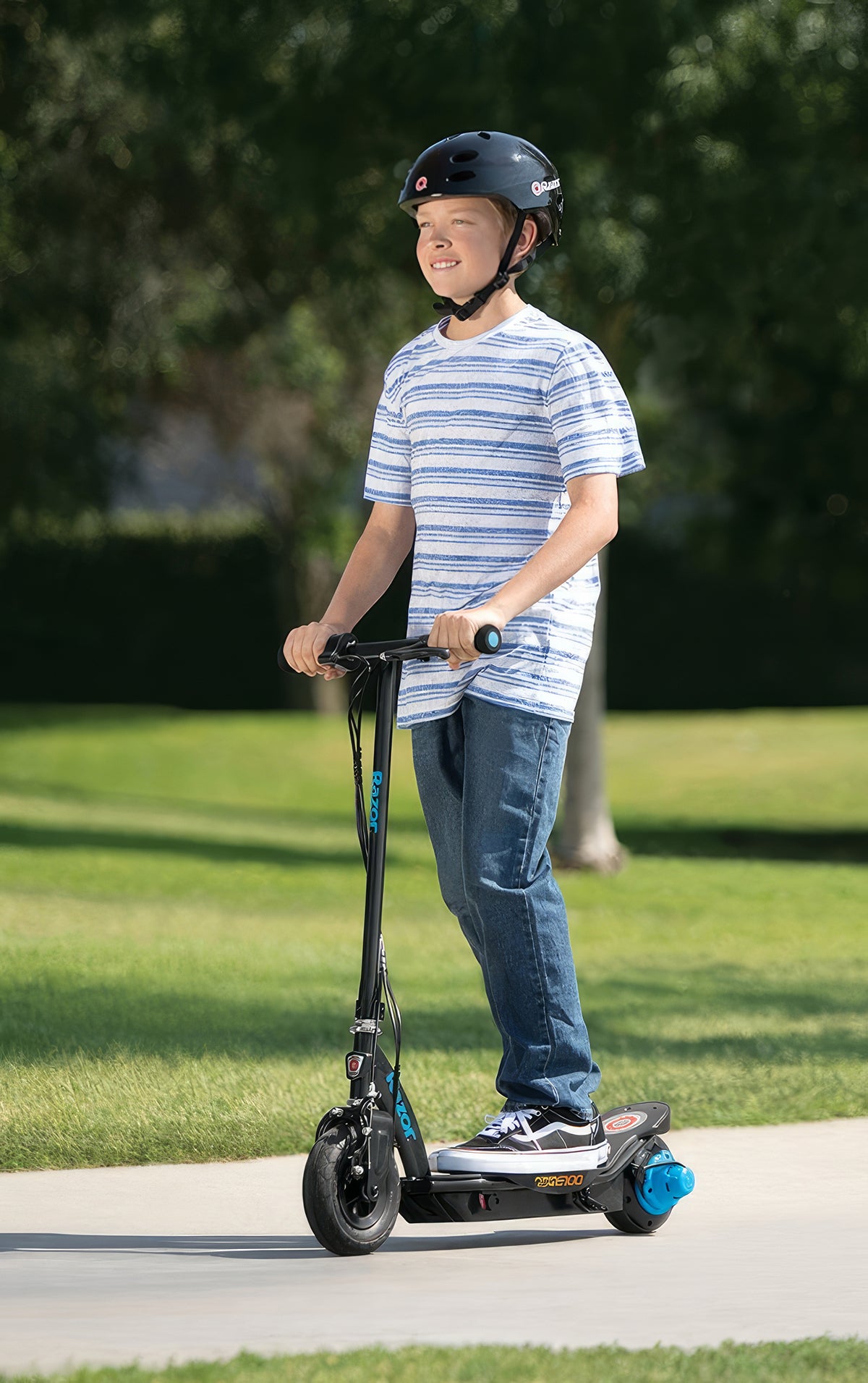 Boy riding a Razor Power Core E100 scooter, emphasizing the 6 Ah 24 Volt Battery Pack for the Razor Power Core E100 (V1+), showcasing its seamless integration and performance.