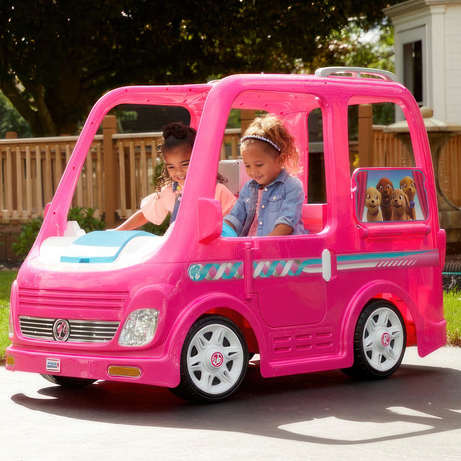 Two girls in a pink toy car, highlighting the need for our 12 Volt Battery Charger for Power Wheels Ride-On Toys.