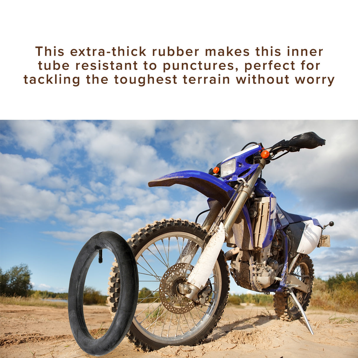 12-1/2x2-1/4 Heavy-Duty Thorn Resistant Scooter Inner Tube with 32mm Straight Valve Stem, shown close-up on a blue motorcycle's wheel parked on a dirt road, emphasizing its durability and rugged design.