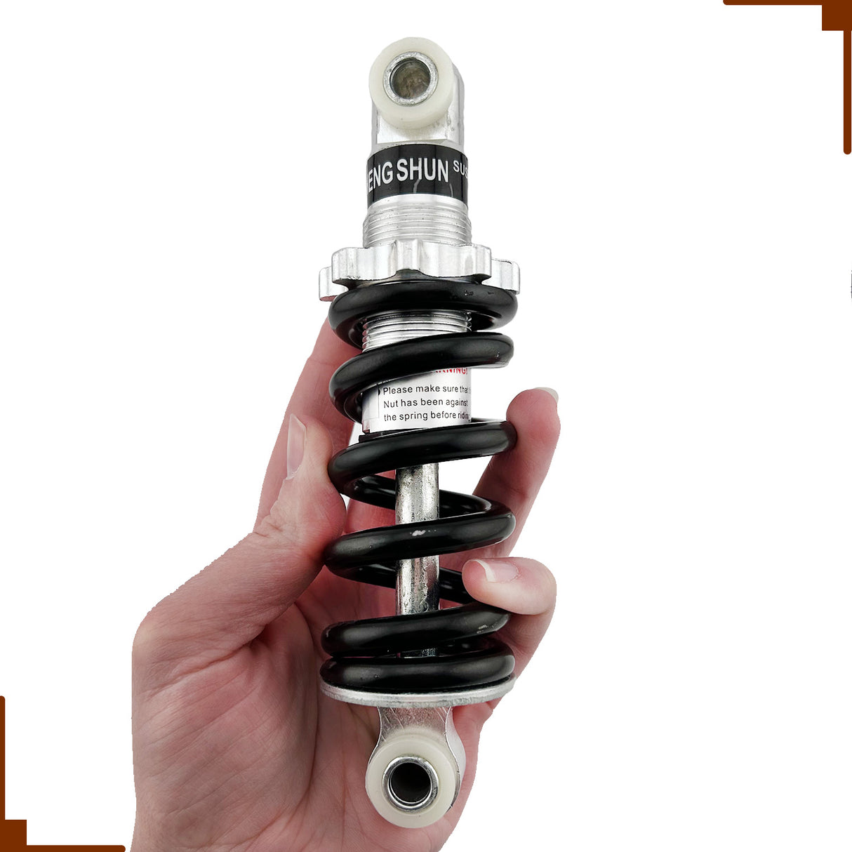 A hand holding a black and silver shock absorber for the Razor Dirt Quad ATV, showcasing its coil and detailed design.