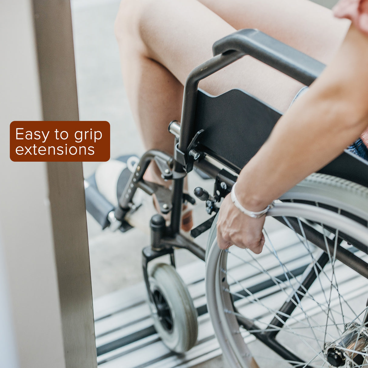 Black Rubber Tips for 5/8 Round Wheelchair Lock Extensions (Set of 2), shown close up on a wheelchair's wheel lock mechanism, highlighting their grip-enhancing texture and fit on the brake lever.