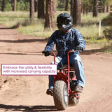 Person riding a Coleman CT200U Trail Mini Bike, showcasing its front and rear cargo racks. The racks are sturdy steel, enhancing the bike's functionality and utility for outdoor adventures.