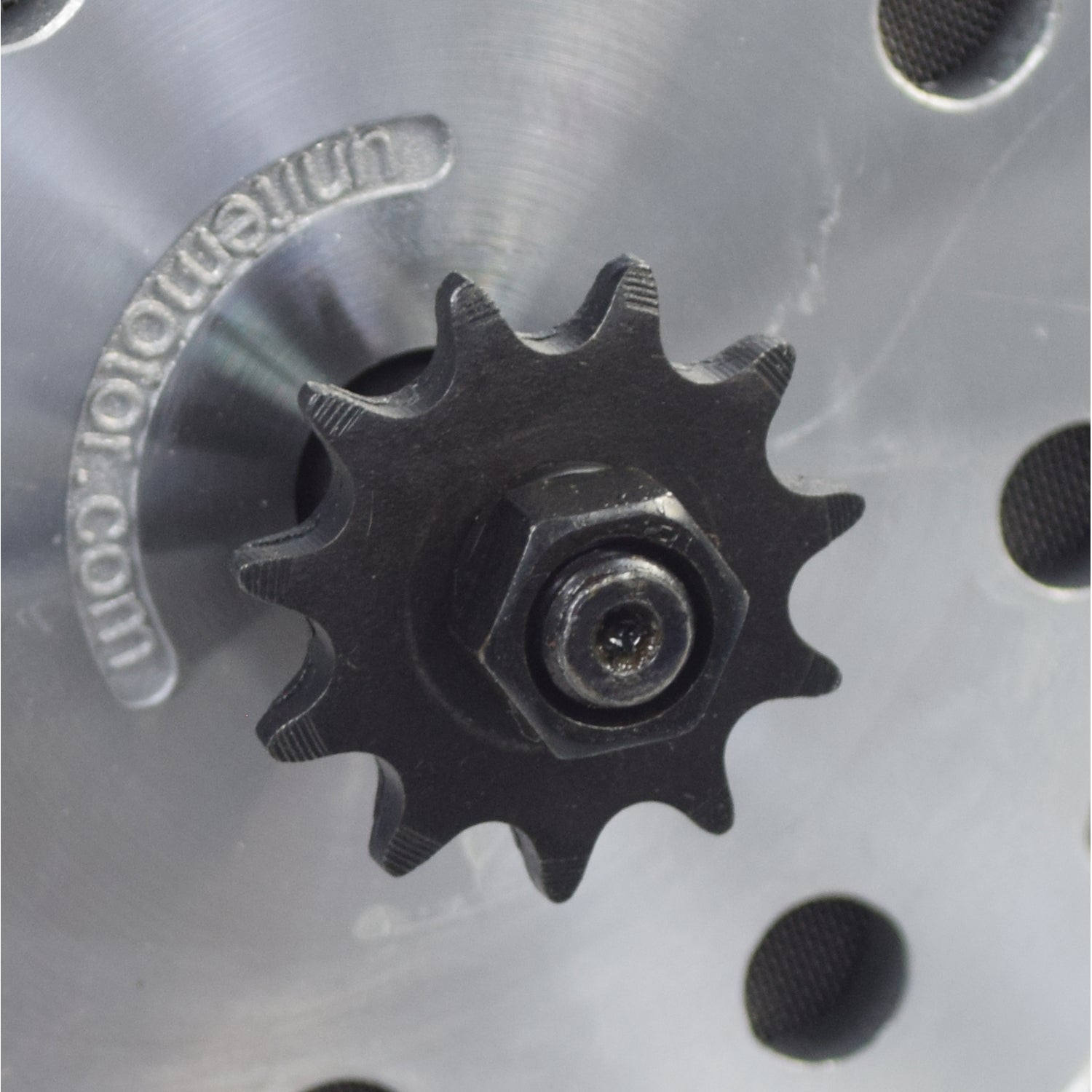 24 Volt 500 Watt Motor, Controller, & Throttle Kit for Electric Scooters, Bikes, & Go-Karts. Close-up of a black gear with a nut on a metal surface.