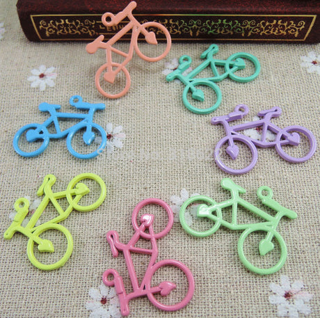 1-1/4 Colored Bicycle Charm Pendant featuring small, detailed bicycle shapes with a handlebar loop for bracelets. Ideal for cyclists' jewelry, available in multiple colors.