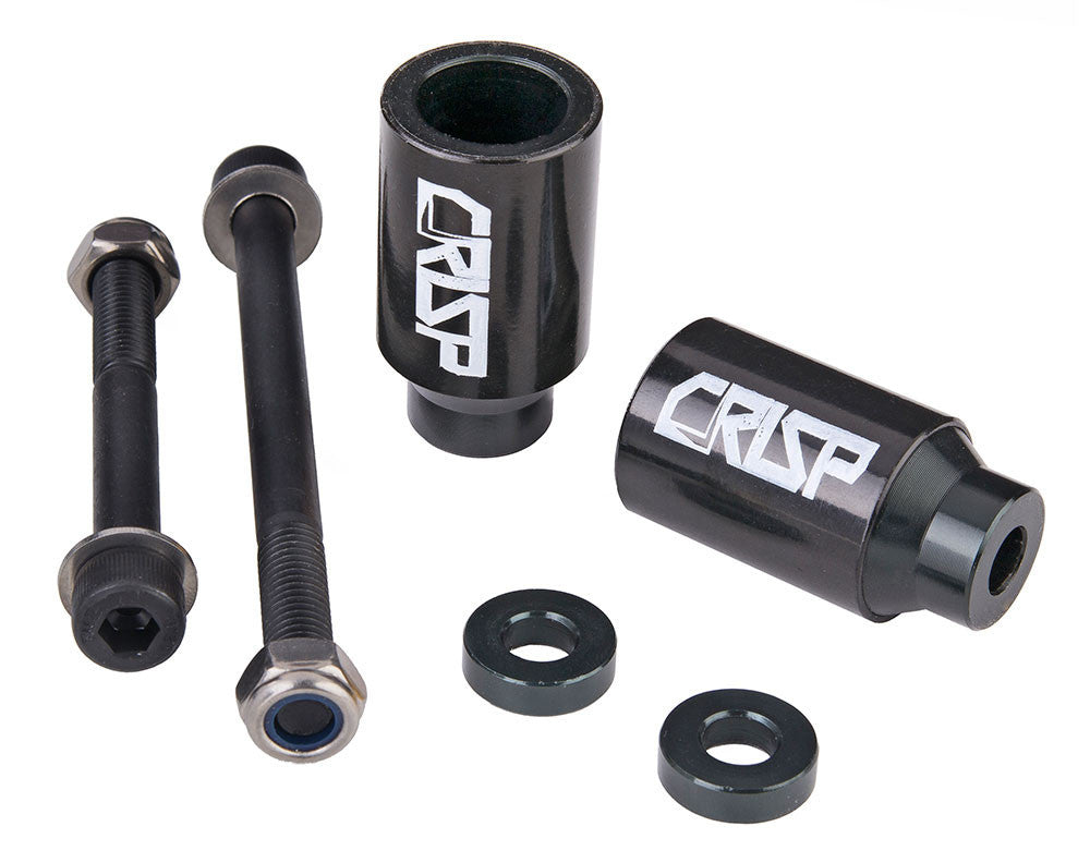 Crisp Chromo Sleeved Peg Set for Kick Scooters showing a group of black cylindrical pegs and metal components, including a black peg with white text, circular objects, and a tube with a screw.