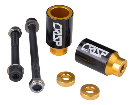 Crisp Chromo Sleeved Peg Set for Kick Scooters, featuring black and gold cylindrical pegs with anodized aluminum alloy cores and chromoly steel sleeves, includes axle bolts, lock nuts, and spacers.