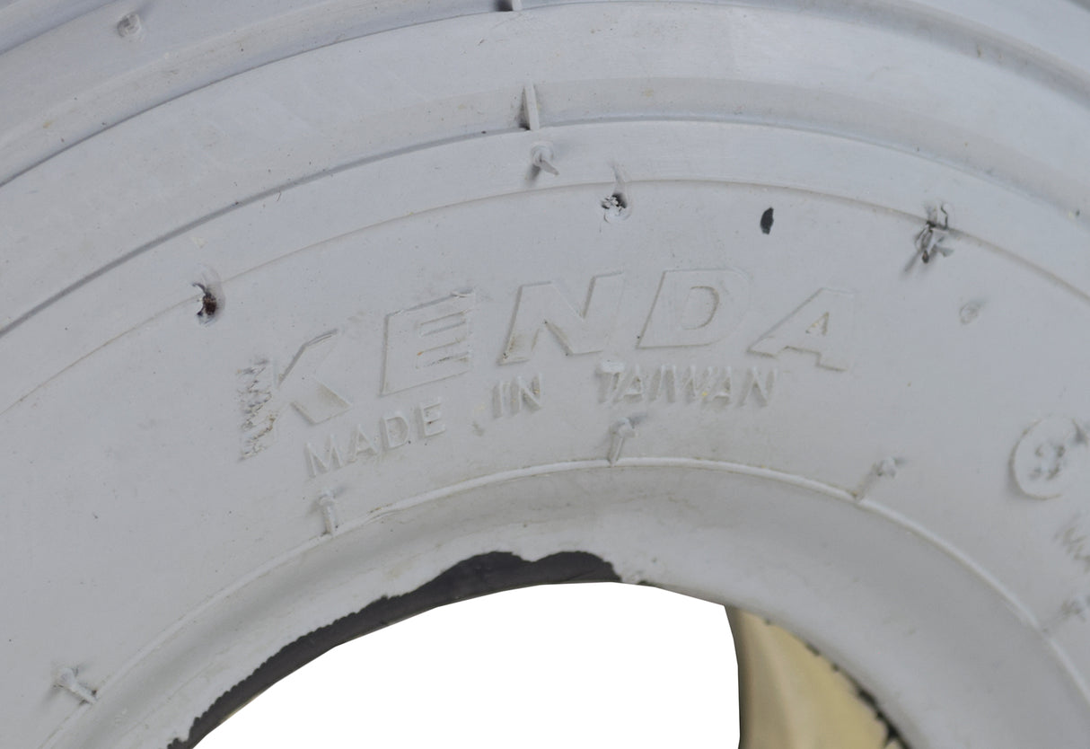 Close-up of the 3.00-4 (10x3, 260X85) Foam-Filled Mobility Tire with K301 Ribbed Tread, showing detailed tread pattern and non-marking gray rubber surface designed for mobility scooters and power chairs.