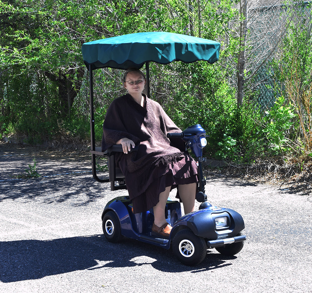 Woman seated on a scooter under a canopy, showcasing the Sun Shade for Scooters & Power Chairs, providing comfort and convenience.