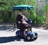 Woman seated on a scooter under a canopy, showcasing the Sun Shade for Scooters & Power Chairs, providing comfort and convenience.