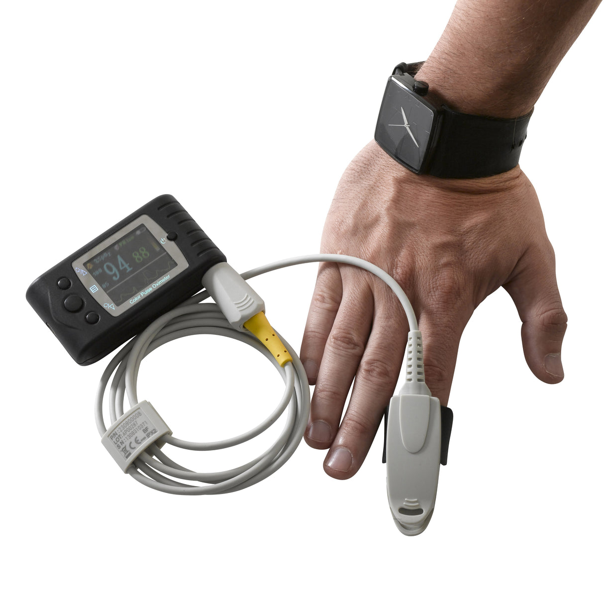 Drive Medical Handy-Ox Digital Color Pulse Oximeter on a wrist, displaying a screen with numeric outputs, and connected to a fingertip probe via wires.