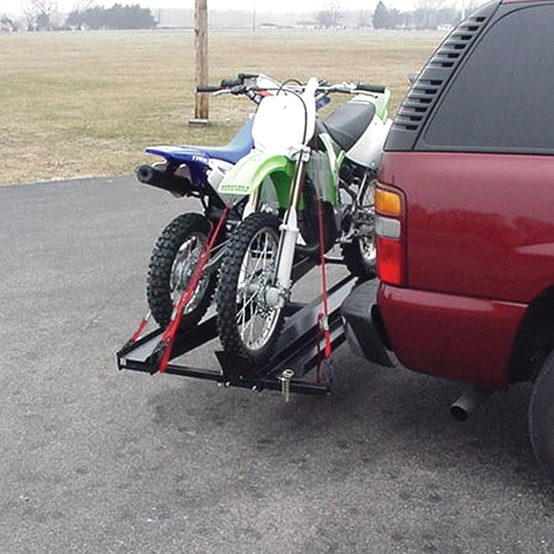 Double Scooter Carrier securely holding a motorcycle on a trailer, attached to the back of a red car, highlighting the carrier's sturdy build and practical design for transporting two motorbikes or scooters.