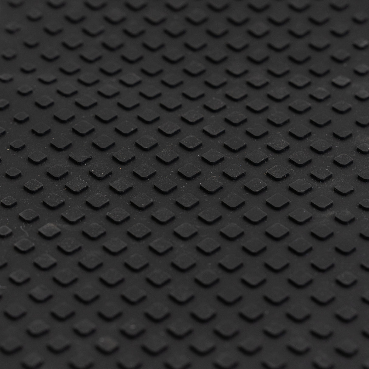 Close-up view of a textured nonslip black rubber Footmat for Ninebot by Segway ES1 & ESB Electric Scooters, designed to rejuvenate the deck frame with peel-and-stick adhesive.