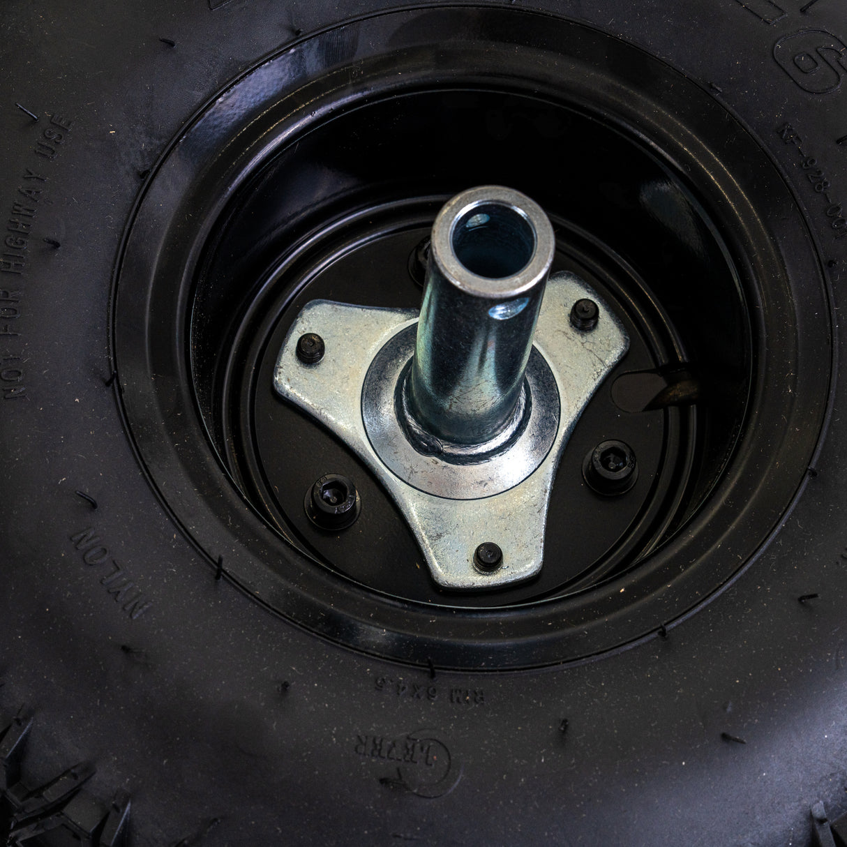 Rear Wheel Assembly for the Razor Dirt Quad 500, featuring a black tire with a metal nut on a steel rim, designed for easy mounting on the electric ATV.