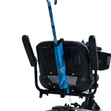 Universal Cane Holder for Mobility Scooters & Power Chairs: A black fabric pouch attached to a power chair's backrest, designed to securely hold a blue cane with an adjustable nylon strap.