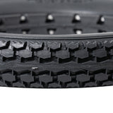 Close-up of the 12-1/2x2-1/4 Dark Gray Solid Urethane Mobility Tire with Knobby Tread, highlighting its robust, flat-free design suitable for both indoor and outdoor use.