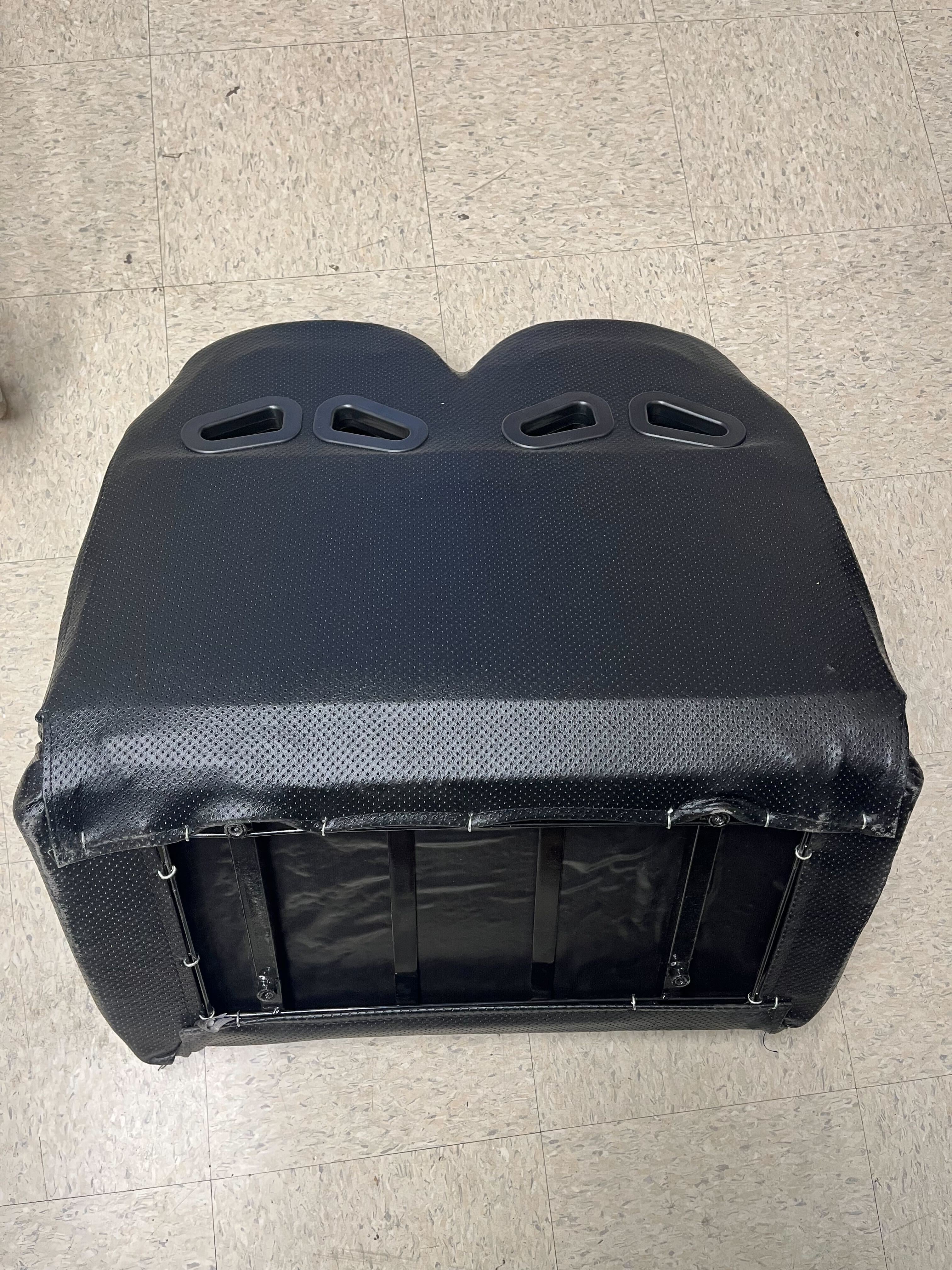 27 Black Double Seat for Go-Karts (Blemished) featuring padded upholstery, multiple holes for ventilation, and compatibility with various models, shown on a floor surface.