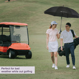 Wind Resistant Vented Golf Umbrella: A man and woman walking on a golf course holding this sturdy, vented umbrella with a soft foam hand grip, designed to resist wind without collapsing.