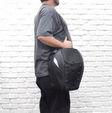 Man holding a black Tail Bag for Electric Bikes with adjustable straps and a shoulder strap, showcasing its versatility as a backpack.