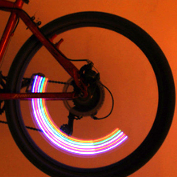 Close-up of a bicycle wheel featuring the Lightning Bug Flashing Valve Cap Light for Bikes & Scooters (Set of 2), highlighting the mounted light on the valve stem designed for increased rider visibility.