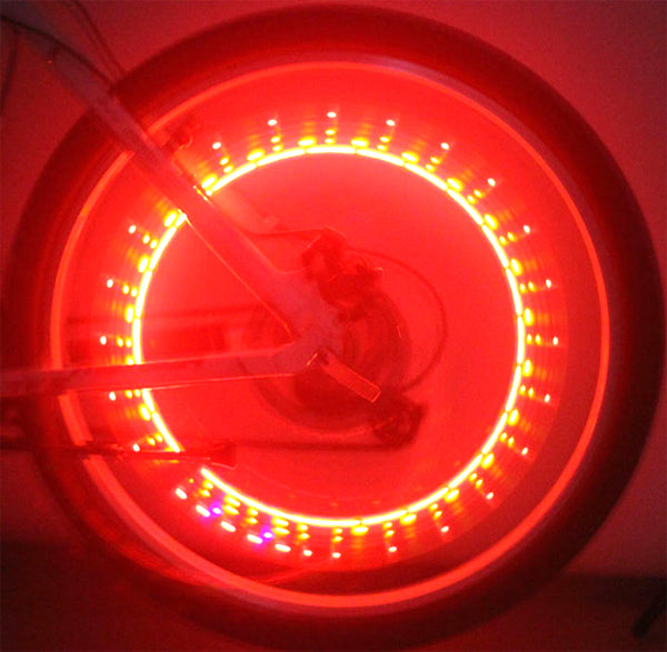 Lightning Bug Flashing Valve Cap Light for Bikes & Scooters (Set of 2) - close-up of a wheel with vibrant red lights, showcasing the dynamic patterns when in motion.