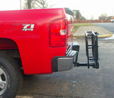 48 x 20 Folding Steel Cargo Carrier attached to a red truck's hitch, featuring reinforced mesh bottom, high tubular rails, and a fold-up design for easy storage.