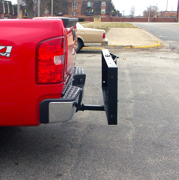 60 x 20 Folding Steel Cargo Carrier attached to the back of a red truck, showcasing its compact, upright folded position with visible mesh bottom and sturdy rails.