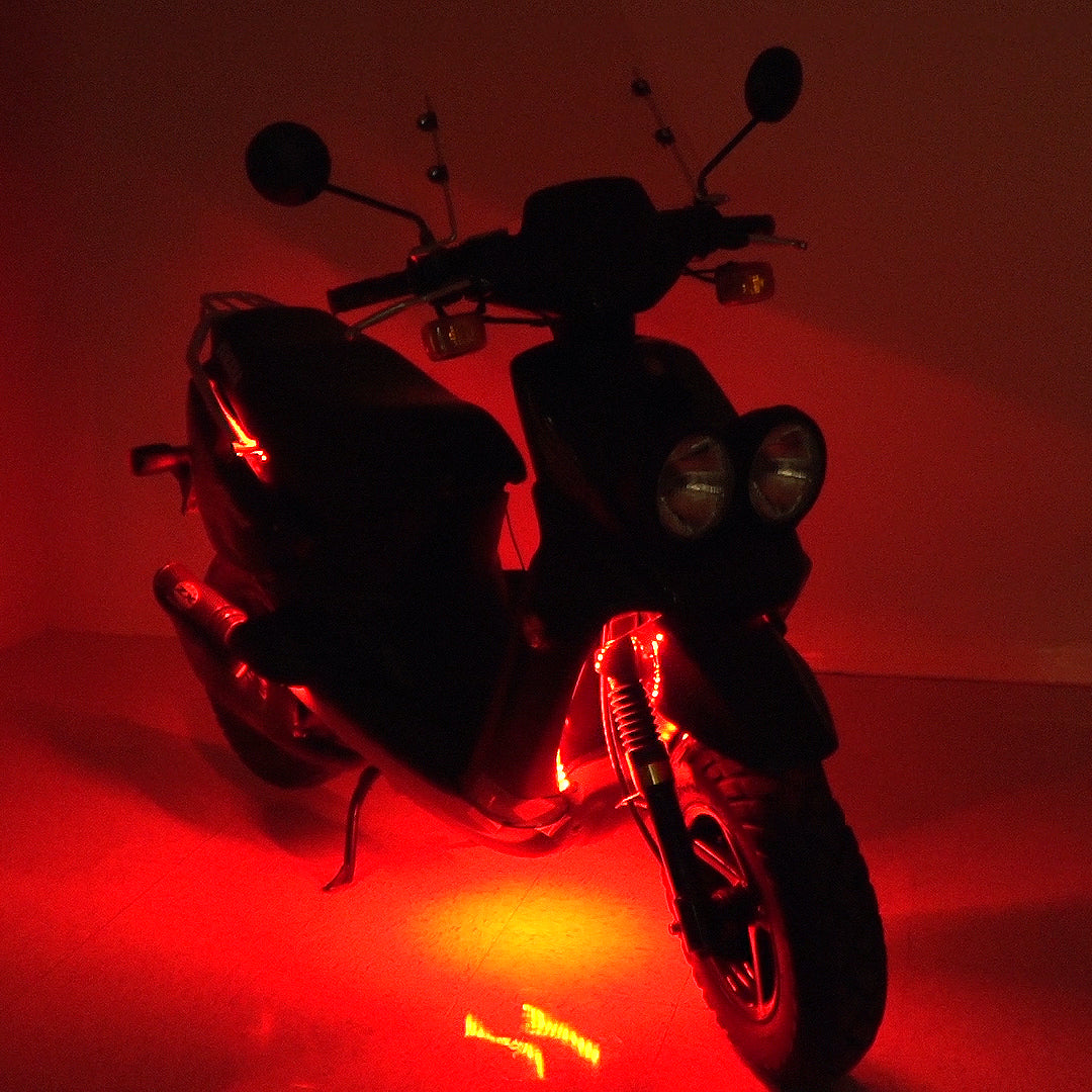 Multi-Color LED Light Kit for Street Scooters, featuring red-lit strips and a close-up of a tire, highlighting the customizable, weather-resistant lighting for a unique scooter appearance.