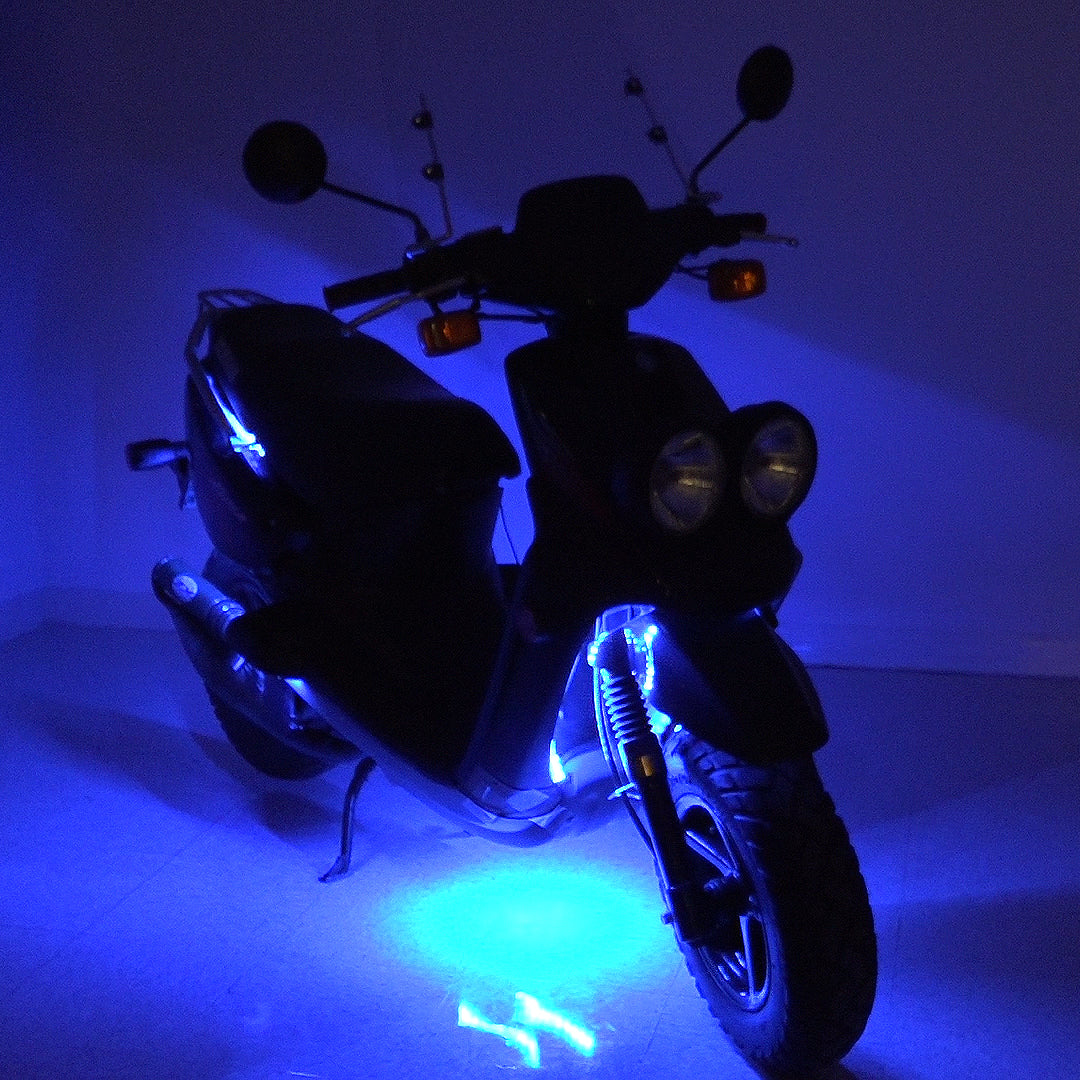 Multi-Color LED Light Kit for Street Scooters showing a scooter equipped with vibrant blue lights, highlighting its wheels and frame, ideal for a striking and customizable night-time visibility.