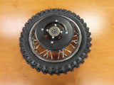 Red Rear Wheel Assembly for the Razor SX500 McGrath Dirt Rocket (Missing Parts), featuring a black tire with metal spokes, displayed on a wooden surface.