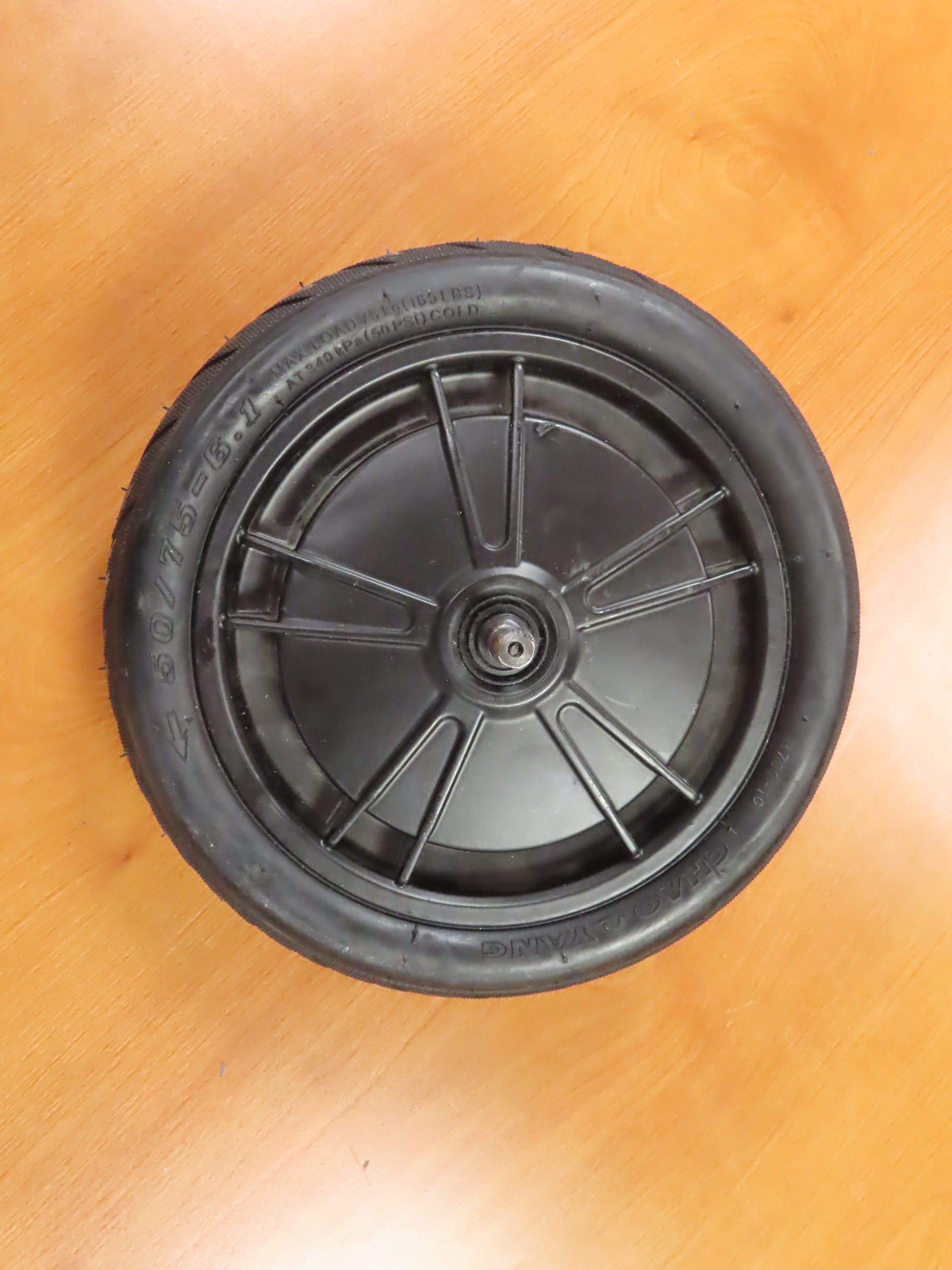 250 Watt Hub Motor & Front Wheel Assembly for GOTRAX GXL V2 & XR Elite Electric Scooters (Blemished) showing a black wheel with a metal center and spoke, placed on a wood surface.