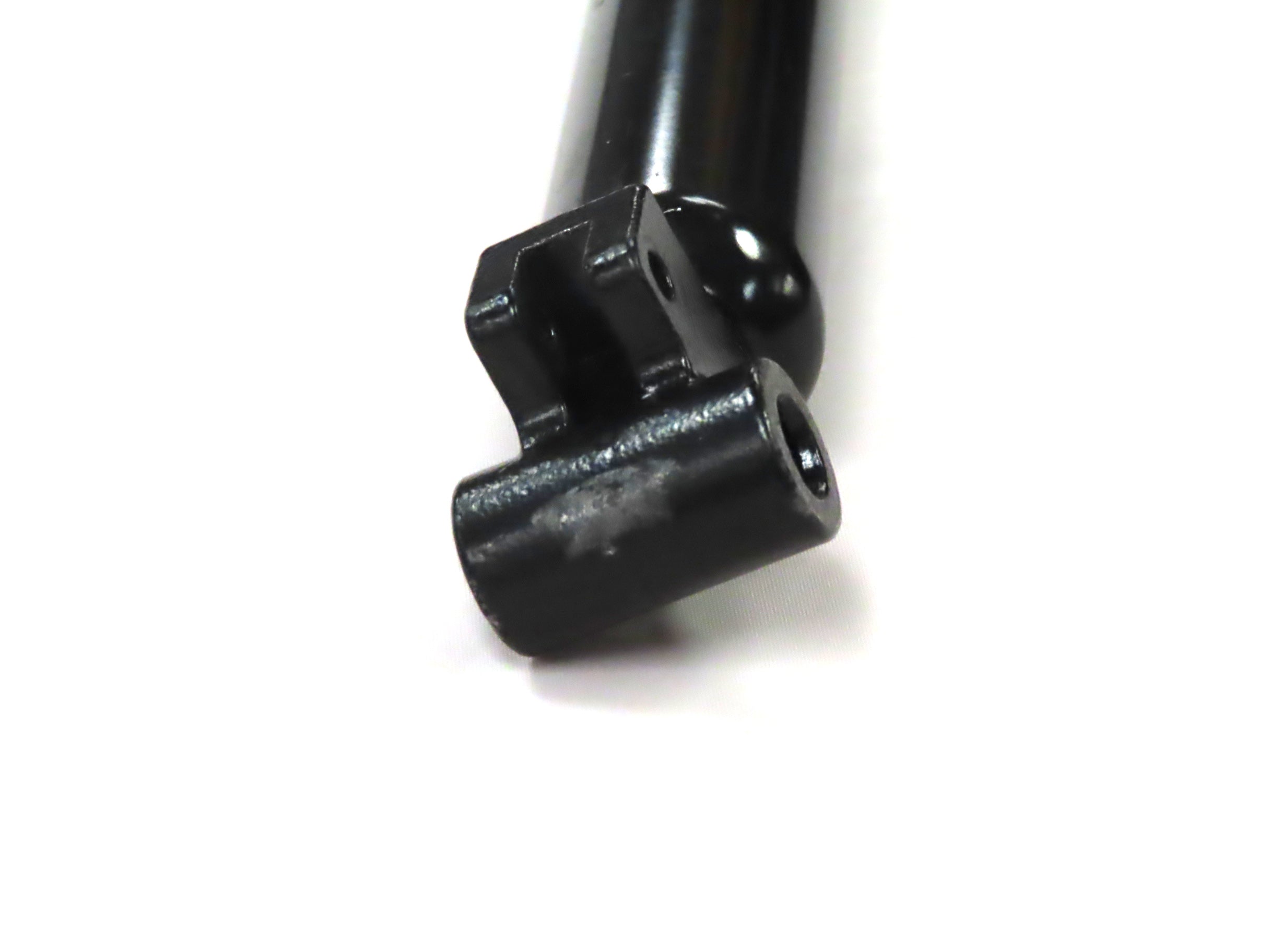 Tiller Gas Shock Assembly for the Golden Technologies Companion I & II (GC221/321/421), showing a close-up of the black metal component with a hole designed to dampen vibrations in mobility scooters.