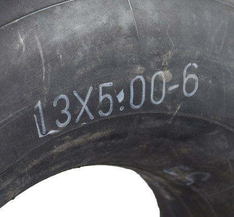 Close-up of the 13x5.00-6 Monster Moto / Mega Moto Go-Kart Inner Tube with Angled Valve Stem, showing tire tread and writing on the surface.