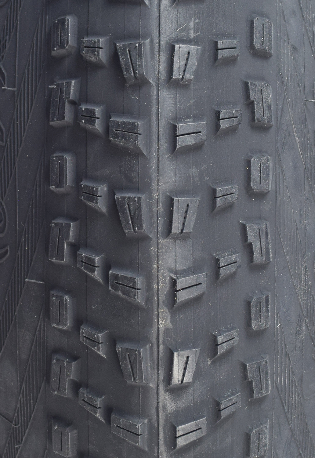 Close-up of the 20 x 4.0 BFT+ Bicycle Tire showcasing its meaty center and side knobs, highlighting the aggressive tread pattern designed for all-mountain and freeride performance, ensuring excellent cornering and braking traction.