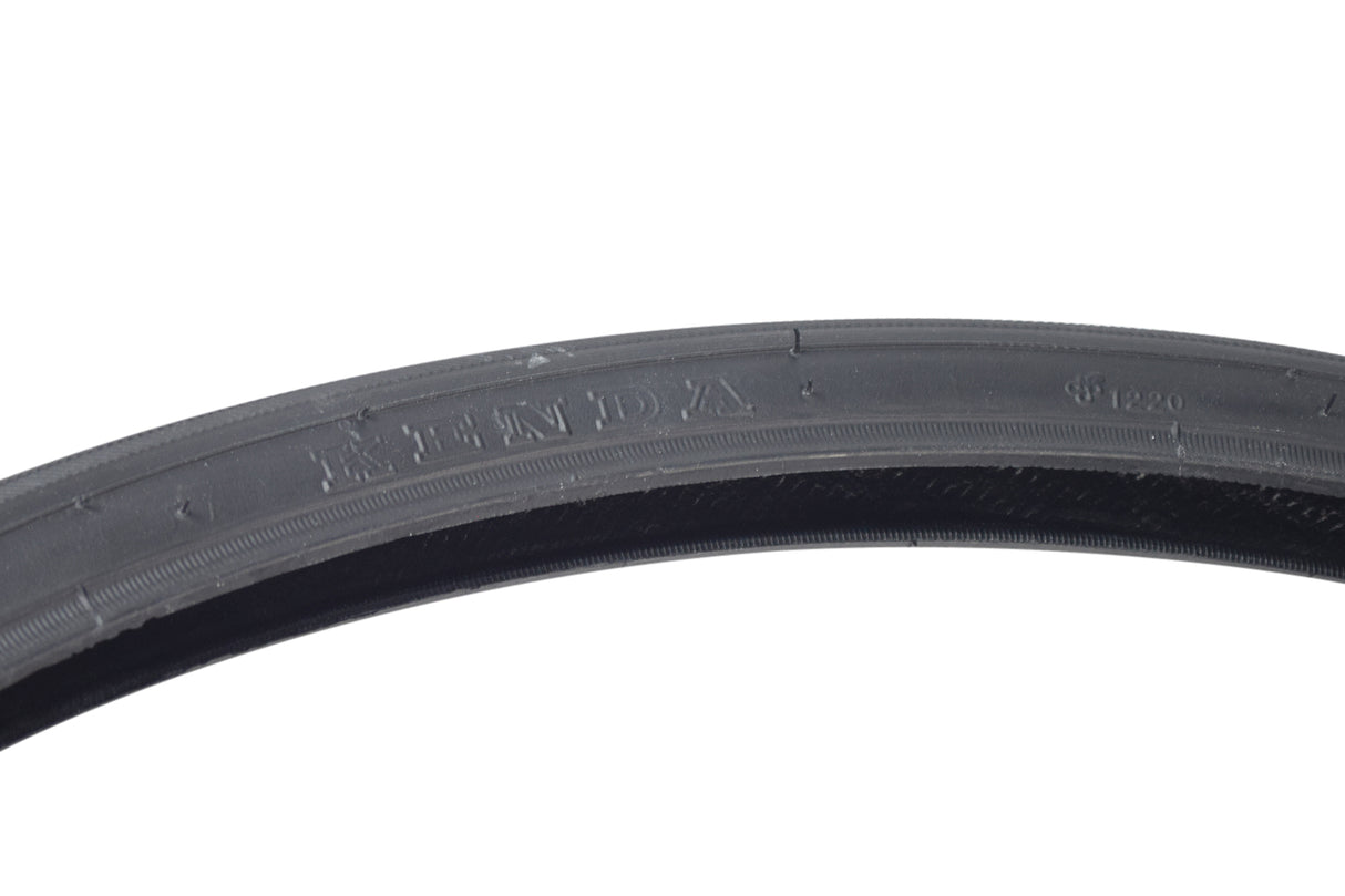 26x1-3/8 Road Raised Center Bicycle Tire, featuring a black rubber design with a raised center tread for reduced rolling resistance and visible text and logo on the sidewall.