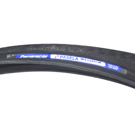 700x32 Pasela Protite Bicycle Tire featuring a close-up view, highlighting its durable tread and blue label. Ideal for urban or touring, it includes advanced puncture protection technology for a reliable ride.