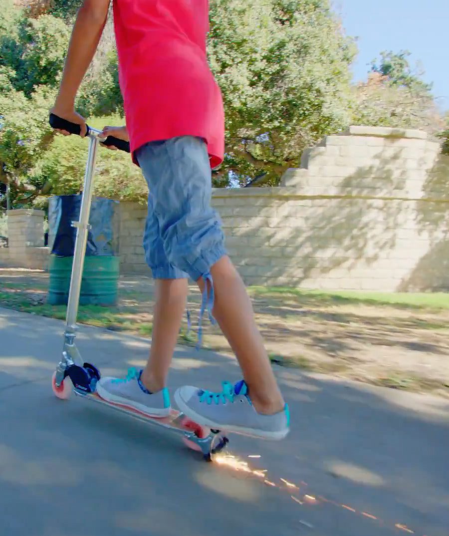 A person is riding a scooter, showcasing the Replacement Spark Cartridge for Razor eSpark, FlashRider 360, & Spark Kick Scooters (Single Cartridge) in action, highlighting its ease of installation and use.