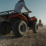 Foot Platforms for 110cc ATVs: A man rides a four-wheeler on a dirt road, highlighting the sturdy and replaceable foot platforms designed for various 110cc ATV models.