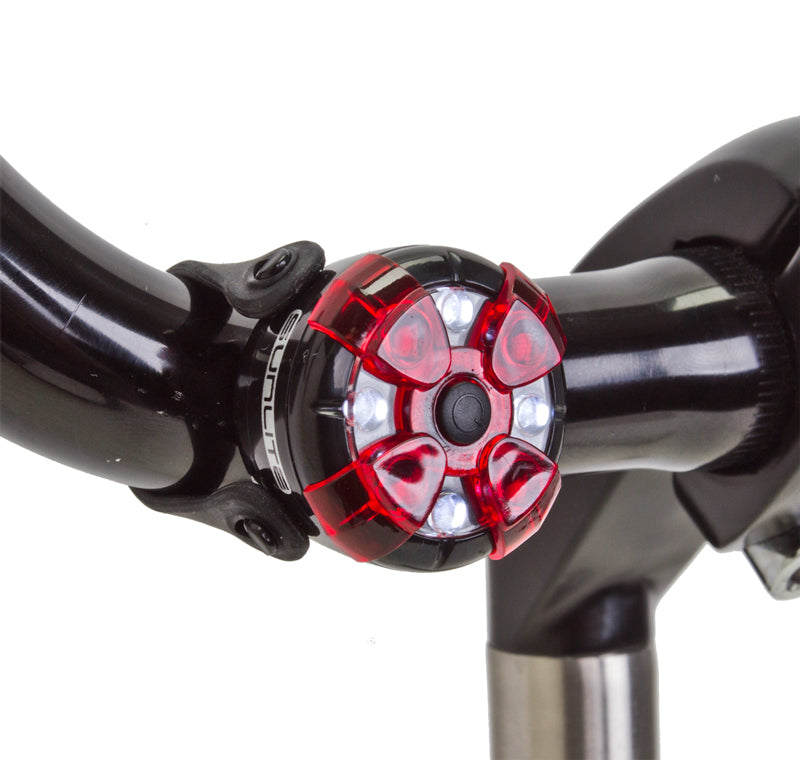 Close-up of the ML-400 Multi Light on a bicycle handlebar, showcasing its sleek titanium build, ideal for scooters and bikes.